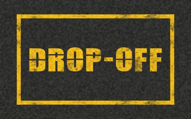 A yellow outlined box on asphalt with DROP-OFF stenciled in yellow
