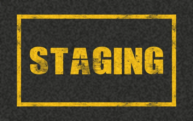 A yellow outlined box on asphalt with STAGING stenciled in yellow